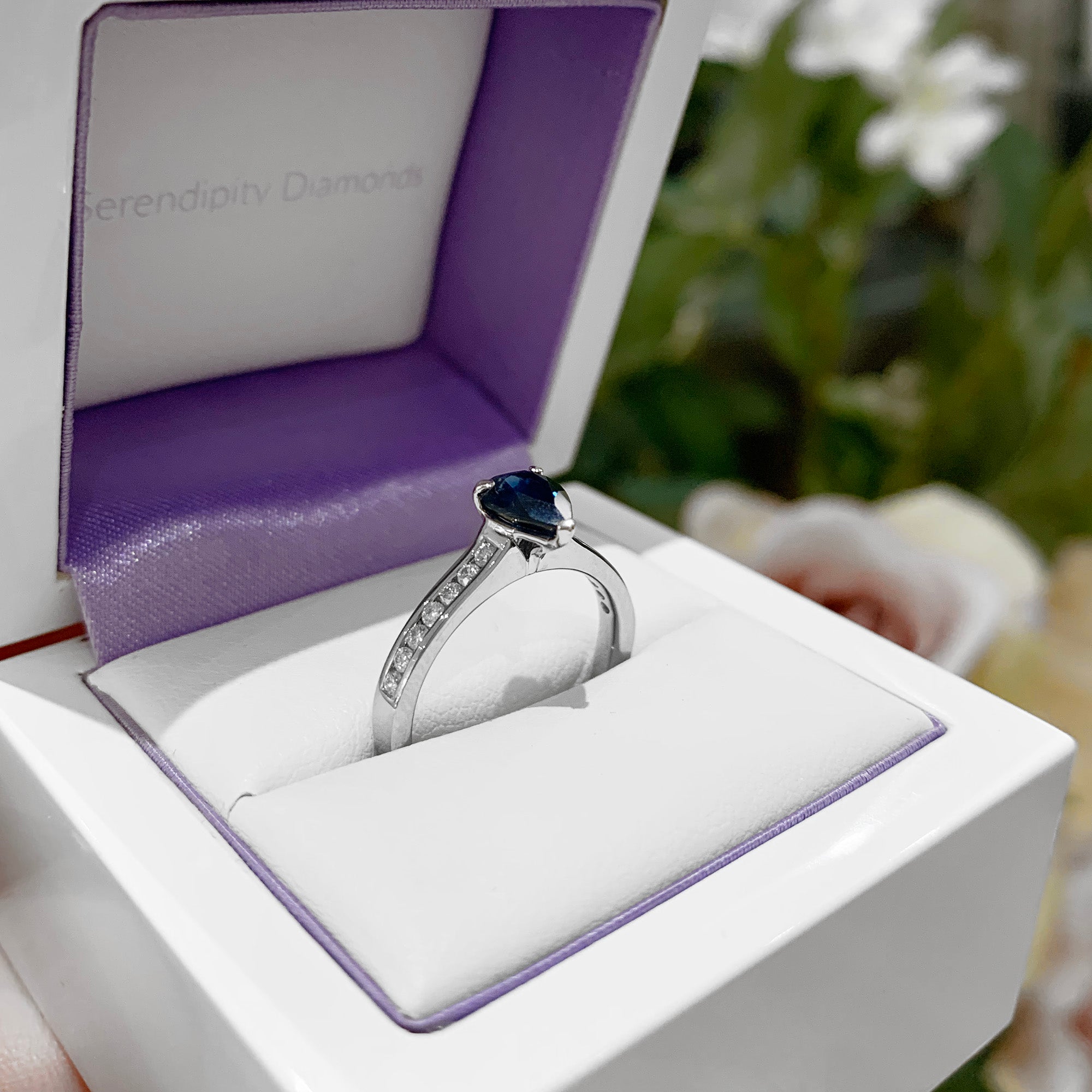 Pear blue sapphire engagement ring photograph in ring box