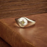Canadamark diamond signet ring - the Aurora Star, shown on a wood background set with the natural fancy yellow diamond in a star setting.