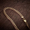24.5 Inch 9ct Yellow Gold Flat Curb Chain on Wood Background