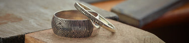 Fingerprint wedding rings on jewellery bench background