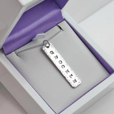 A silver rectangular Isle of Wight pendant necklace engraved with the word 'GROCKLE' hand stamped onto 925 Sterling Silver. 