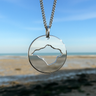 Isle of wight cutout necklace shown in front of Ryde beach on the Isle of Wight