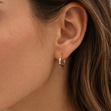 Rose gold hoop earrings in ear
