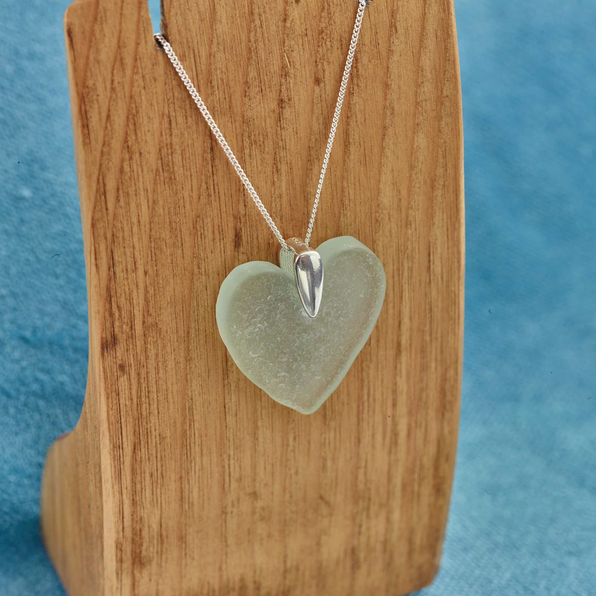 Silver sea glass heart necklace on stand