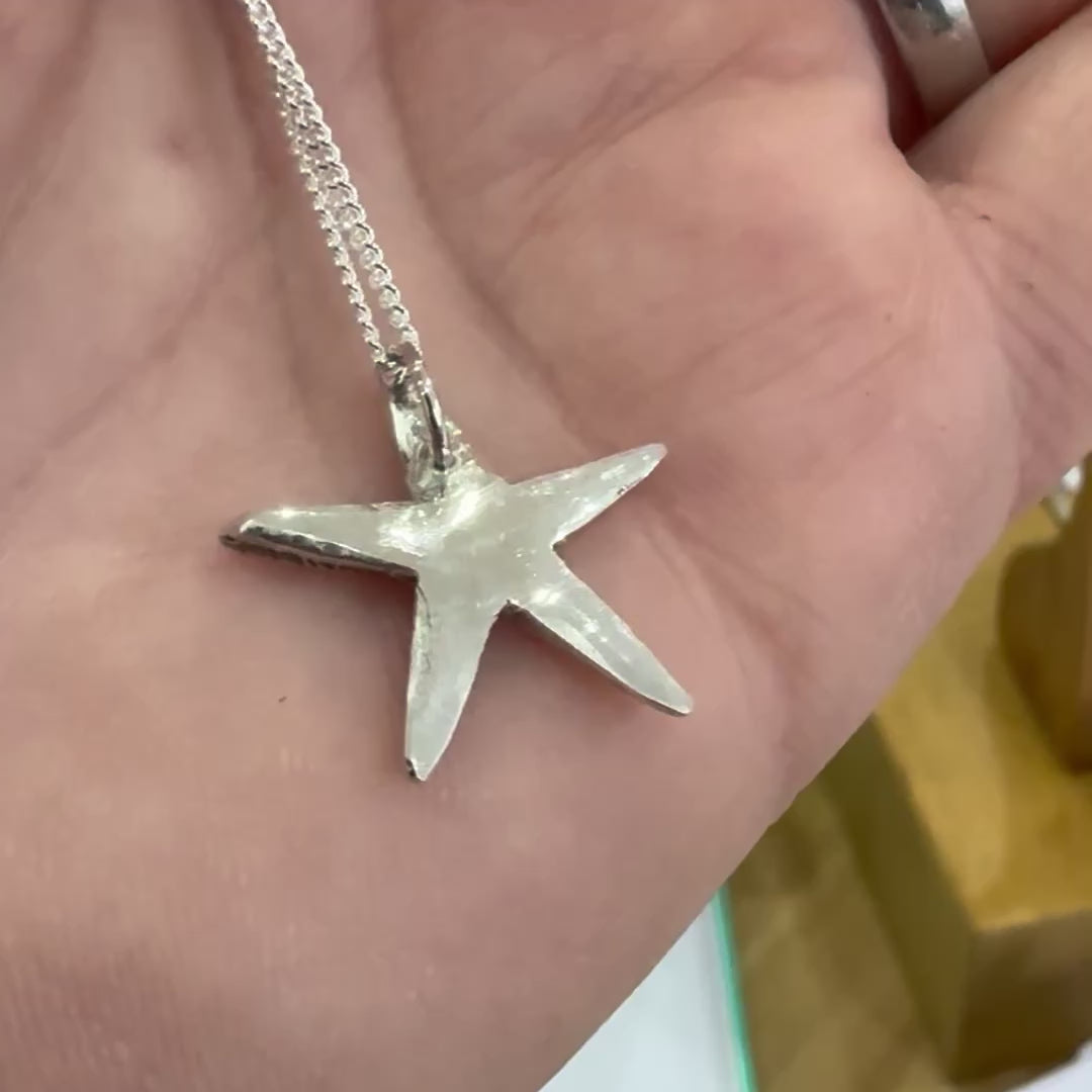 Starfish in hand video showing back of pendant