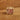 Gold Shilling Charm 1960's on Wood Background